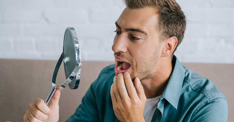 Man looking at the mirror with mouth open